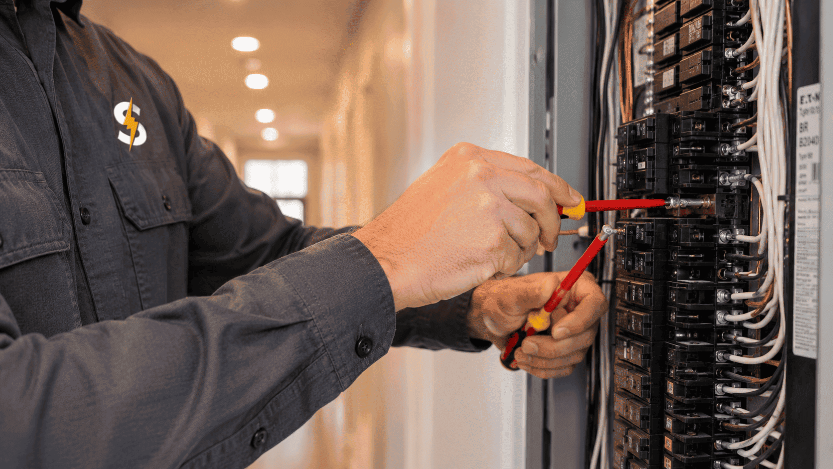 Electrician working on circuit breaker panel